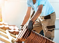 Tiler covering roof with new tile