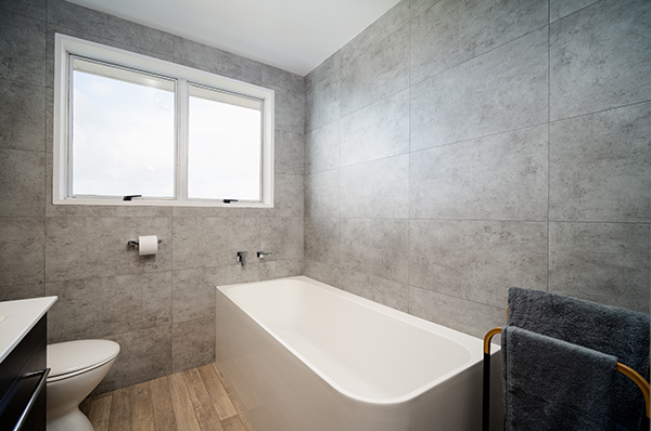 This project completely transformed two bathrooms that were stuck in the 1970s, renewing both interiors with sophisticated designs.