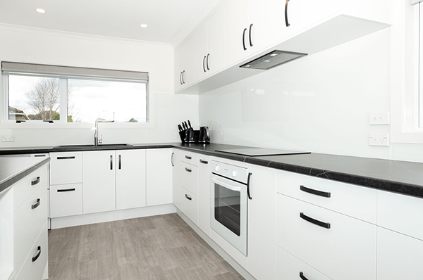 This home's kitchen, lounge, bathroom, and laundry room were renovated with a sleek, modern design that contrasts significantly from the build