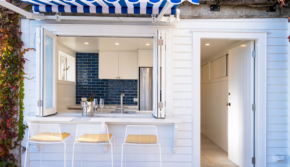 Basement with an indoor outdoor flow, with a bar style window with outdoor seating.
