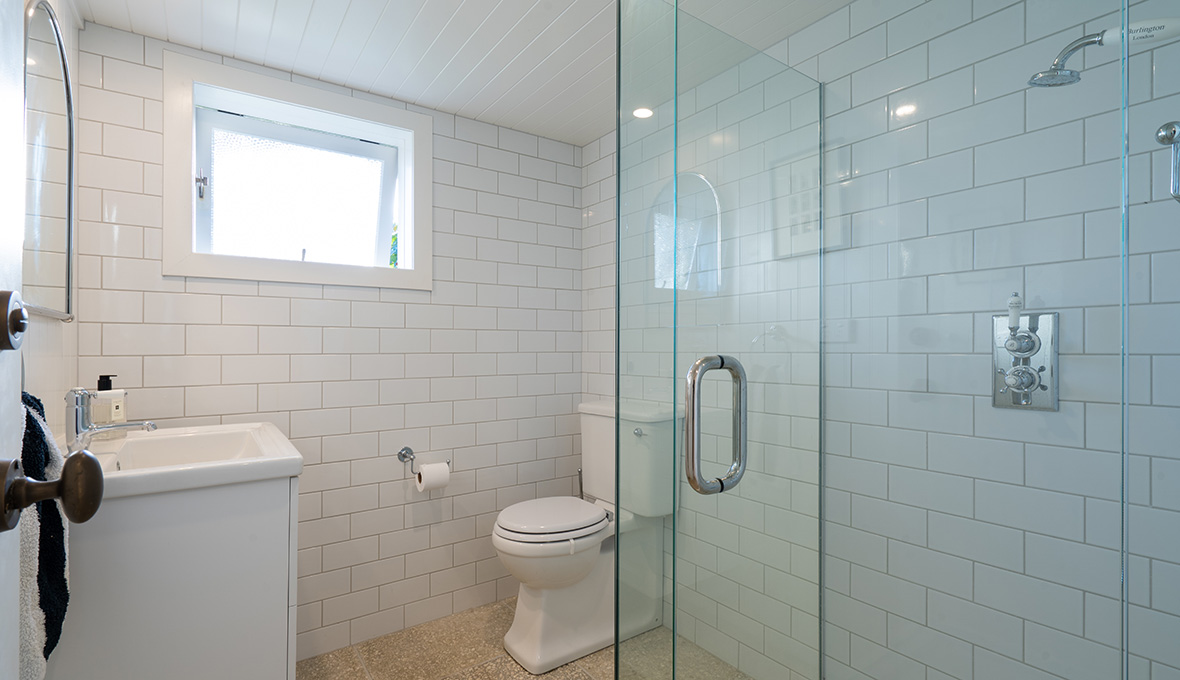 Basement remodel with white bathroom and floor to ceiling tiles