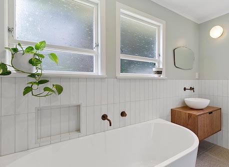 Bathroom with freestanding tub and white wall tiles