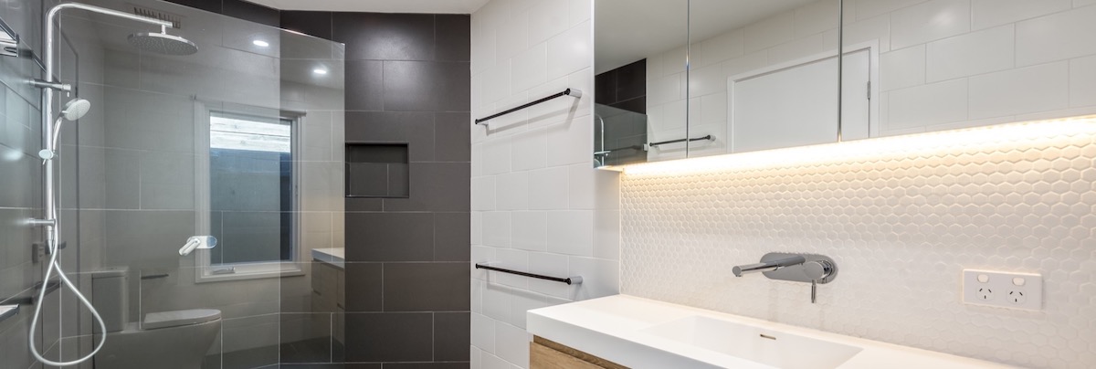 A completed Bathroom Remodel in Boulder showcasing a black tiled feature wall.