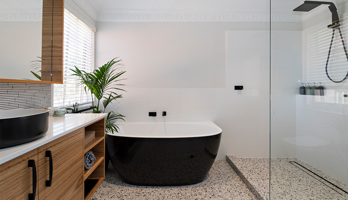 Black freestanding bathtub and walk in shower with black fixtures in Boulder.