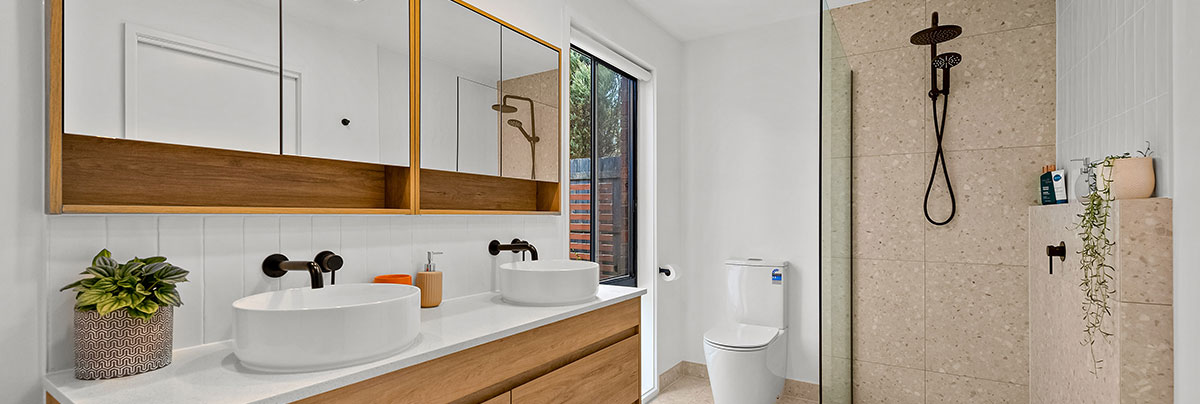 Bathroom with floor to ceiling tiles and double vanoty