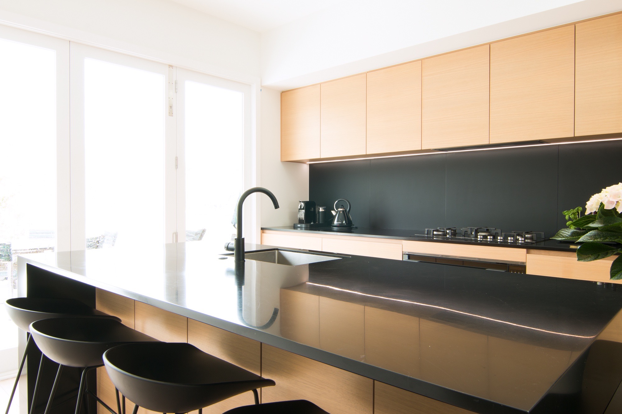 sleek black kitchen with timber accents