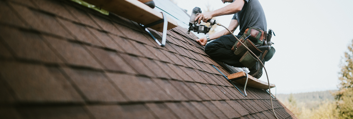 roofer putting a new roof on a house